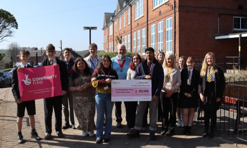 Students and staff stood outside QE School holding a large cheque for £20,000 National Lottery Grant